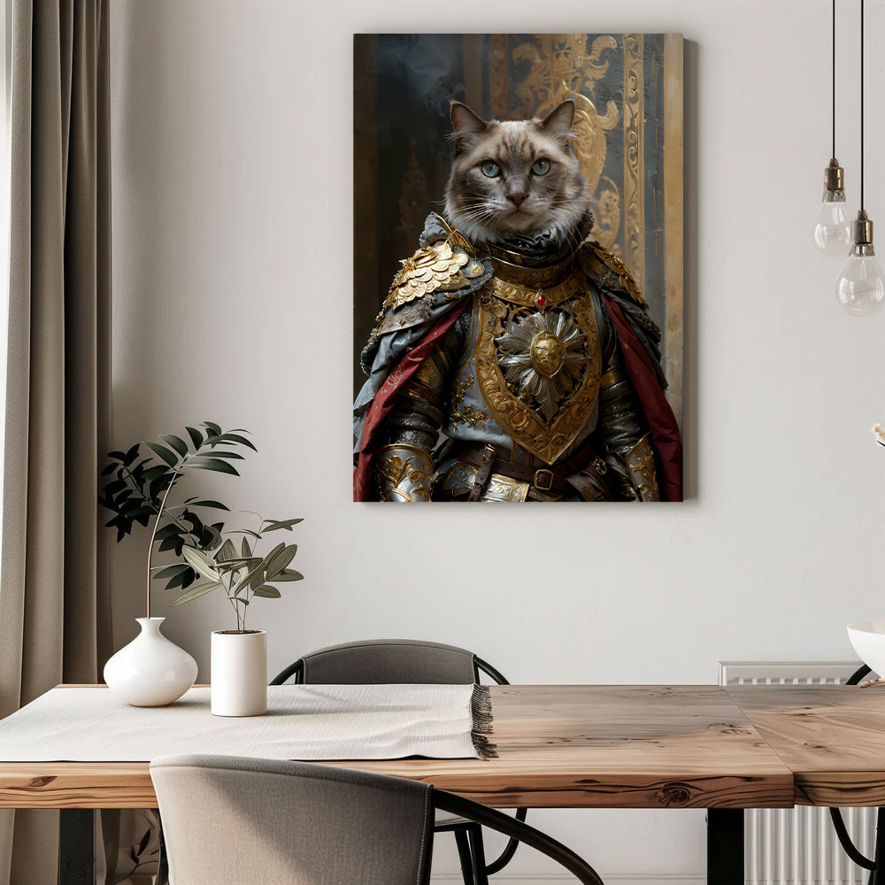 A regal cat portrait hangs on a light gray wall above a wooden dining table. The canvas features a majestic-looking cat dressed in an ornate royal suit of armor adorned with intricate gold detailing, a red cape, and a lion-shaped emblem on the chest plate. The background of the portrait showcases an elegant, gilded palace interior. Below, the dining area includes a wooden table with a white table runner, a potted plant in a vase, and modern chairs, creating a sophisticated yet cozy setting.